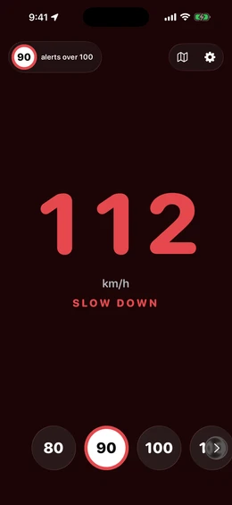 The red SLOW DOWN state: 112 km/h in red over a 90 limit, with the warning text below the readout